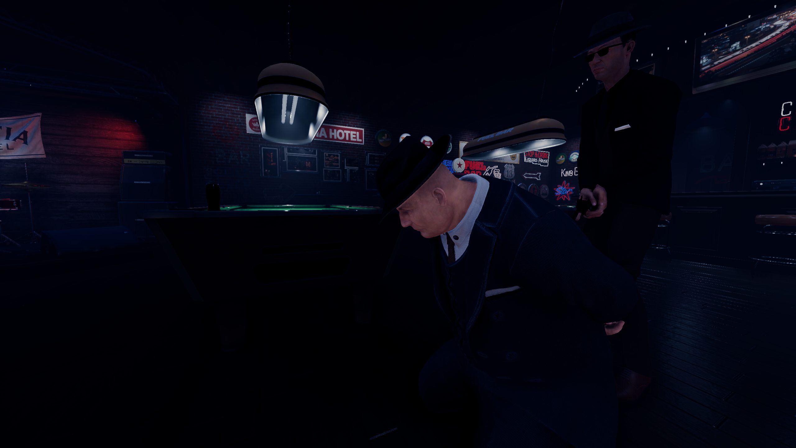 A Mafia member standing behind another guest in the dark bar